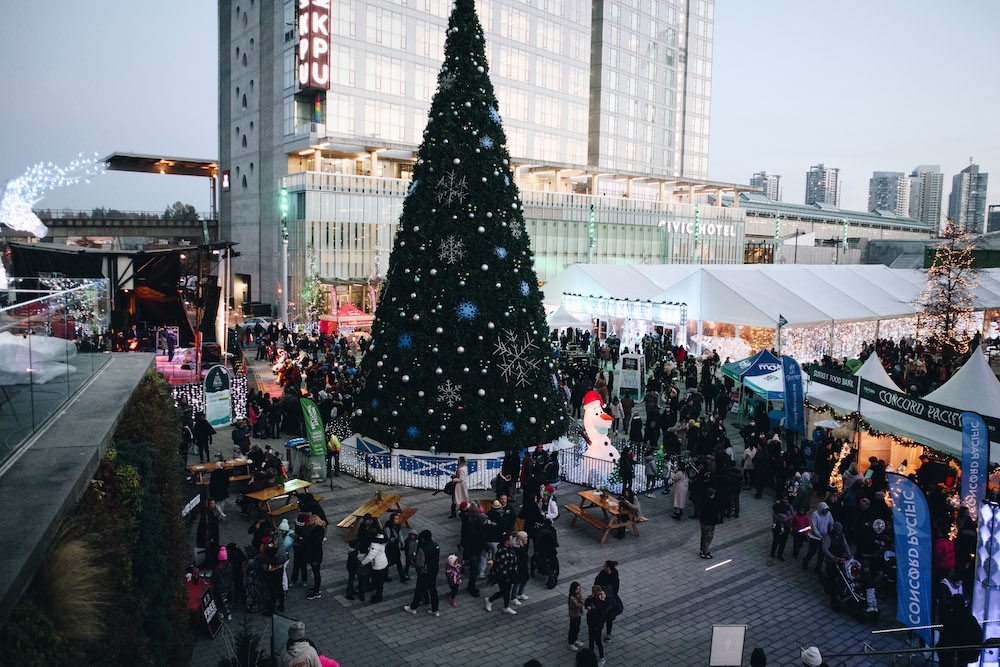 Tree and plaza with festival goers in the daytime