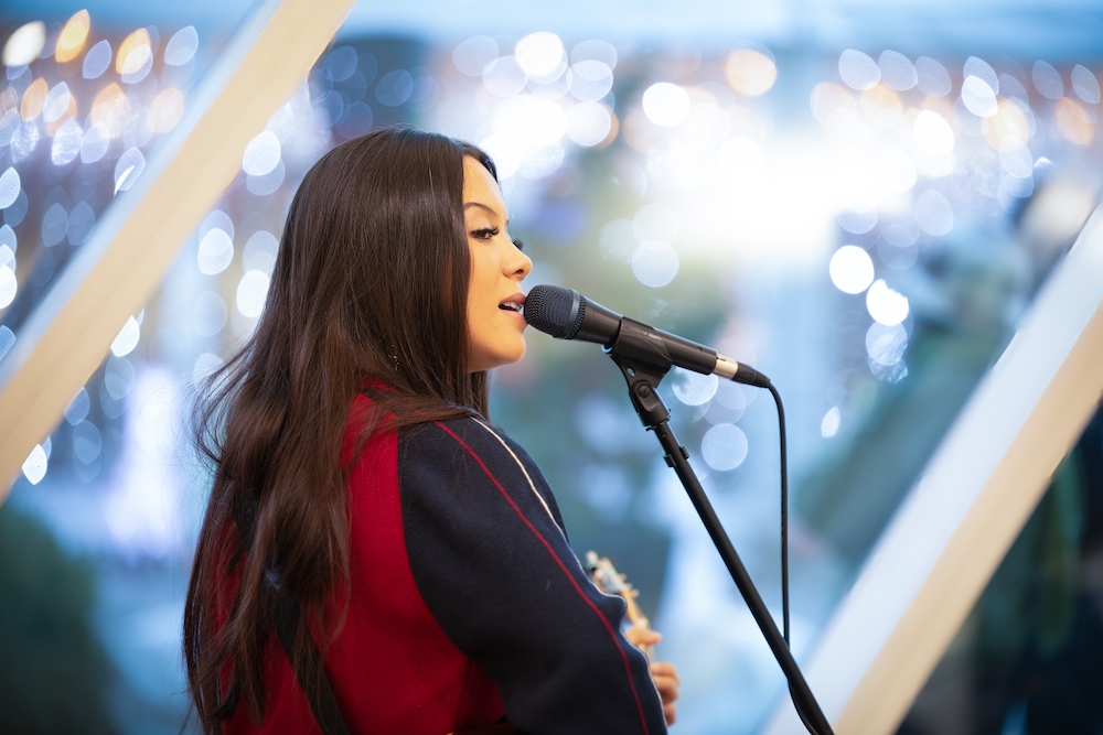 Young woman solo singer guitar-player performing