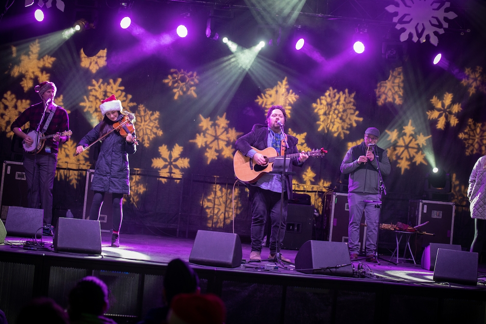 Five-piece band with Celtic folk musical instruments and lead singer perform on stage