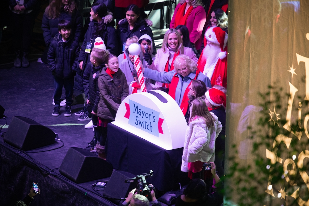 Mayor Locke with Santa and group of children stand by with giant candy-cane tree lighting switch